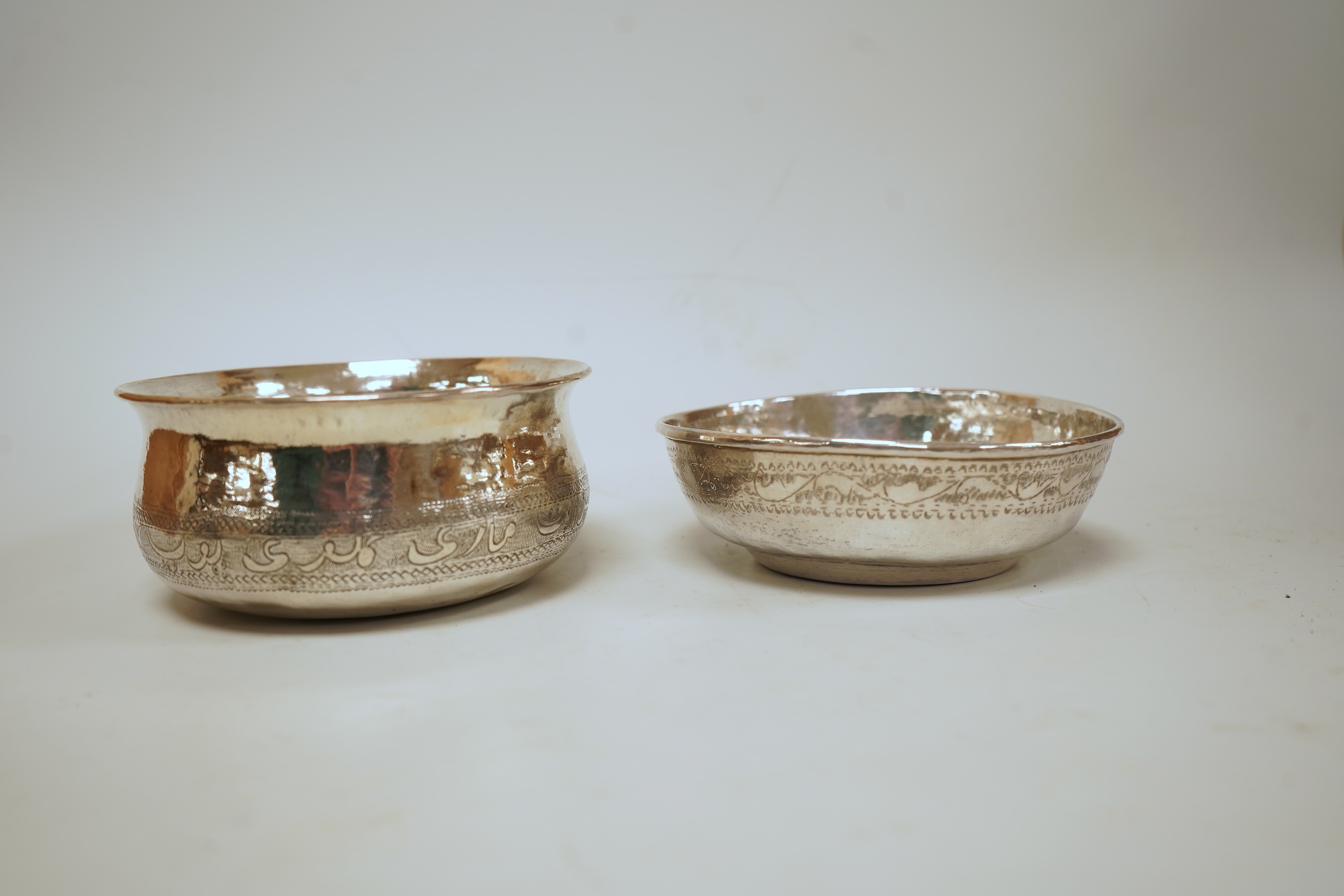 Two early to mid 20th century Persian engraved white metal bowls, both diameters approximately 11.5cm.